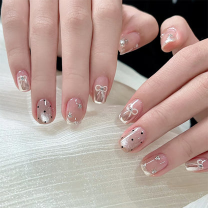 Kunstvolle Nagelkunst mit Schleifen- und Glitzerakzenten Brehn