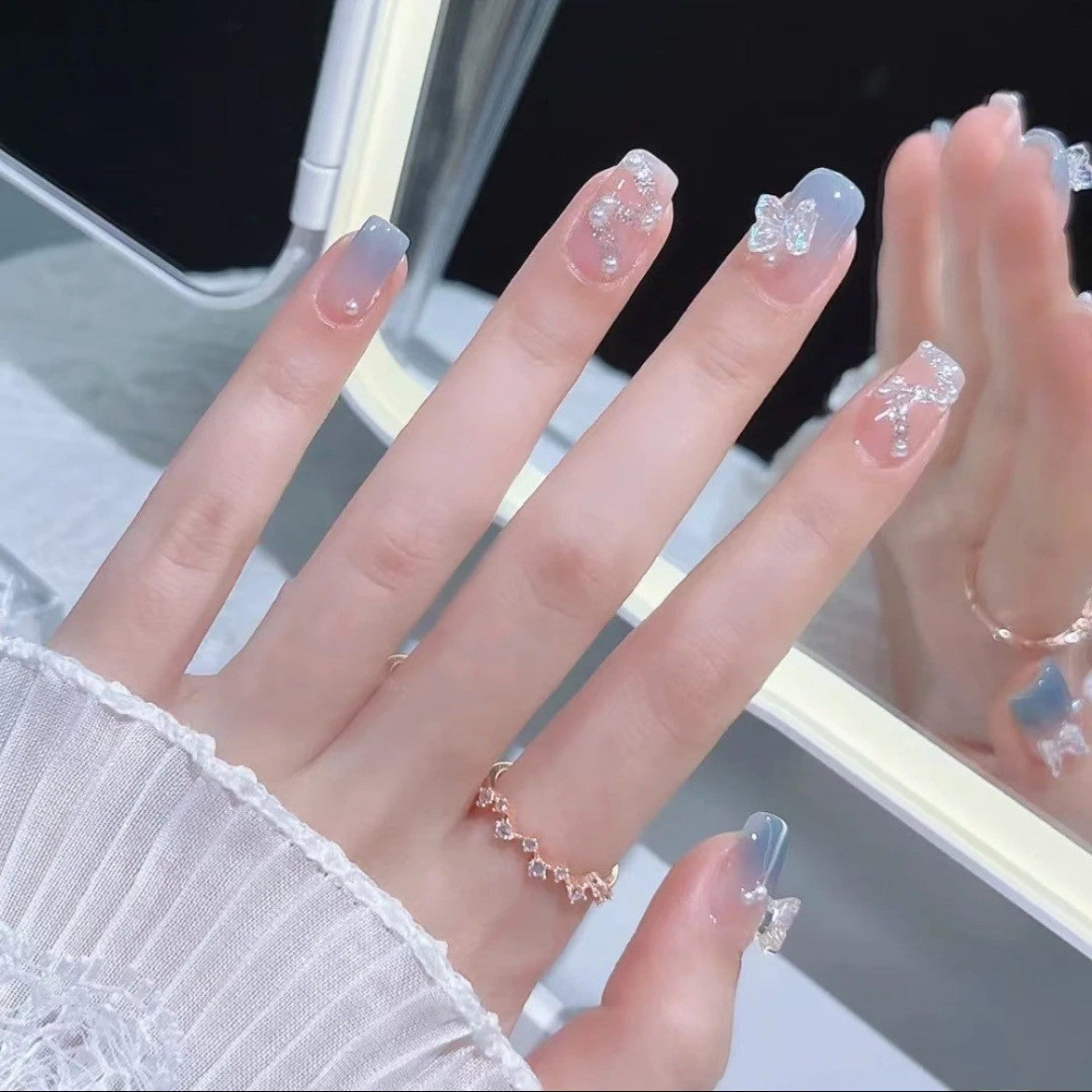 Kunstvolle Nagelverzierung mit Glitzer- und Schmetterlingsdetails Brehn
