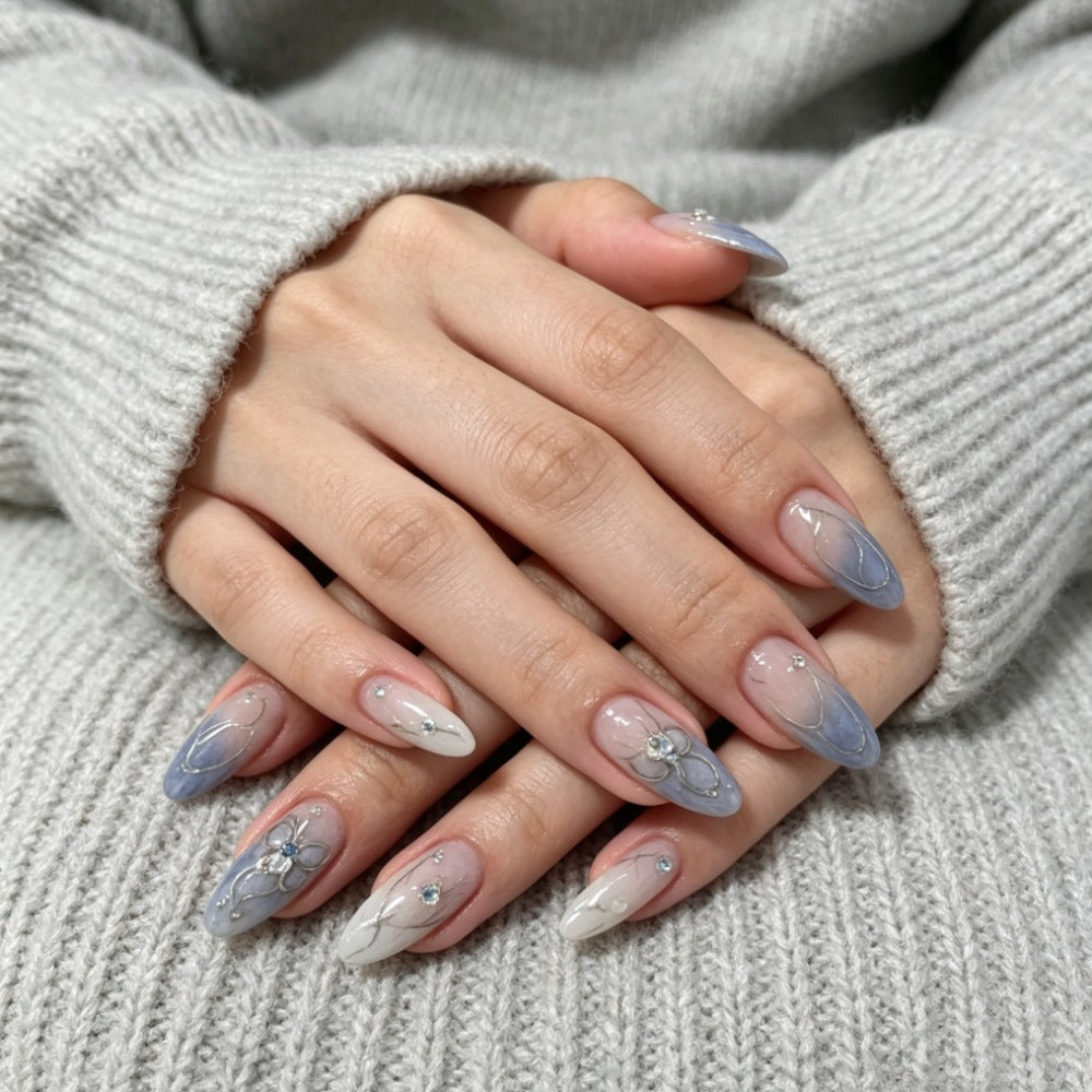 Künstlerisches Press-On-Nageldesign mit floralen und Schmuckakzenten Brehn