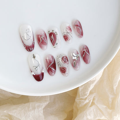Künstlerisches Press-On-Nagelset mit floralen Designs und Steindekoren