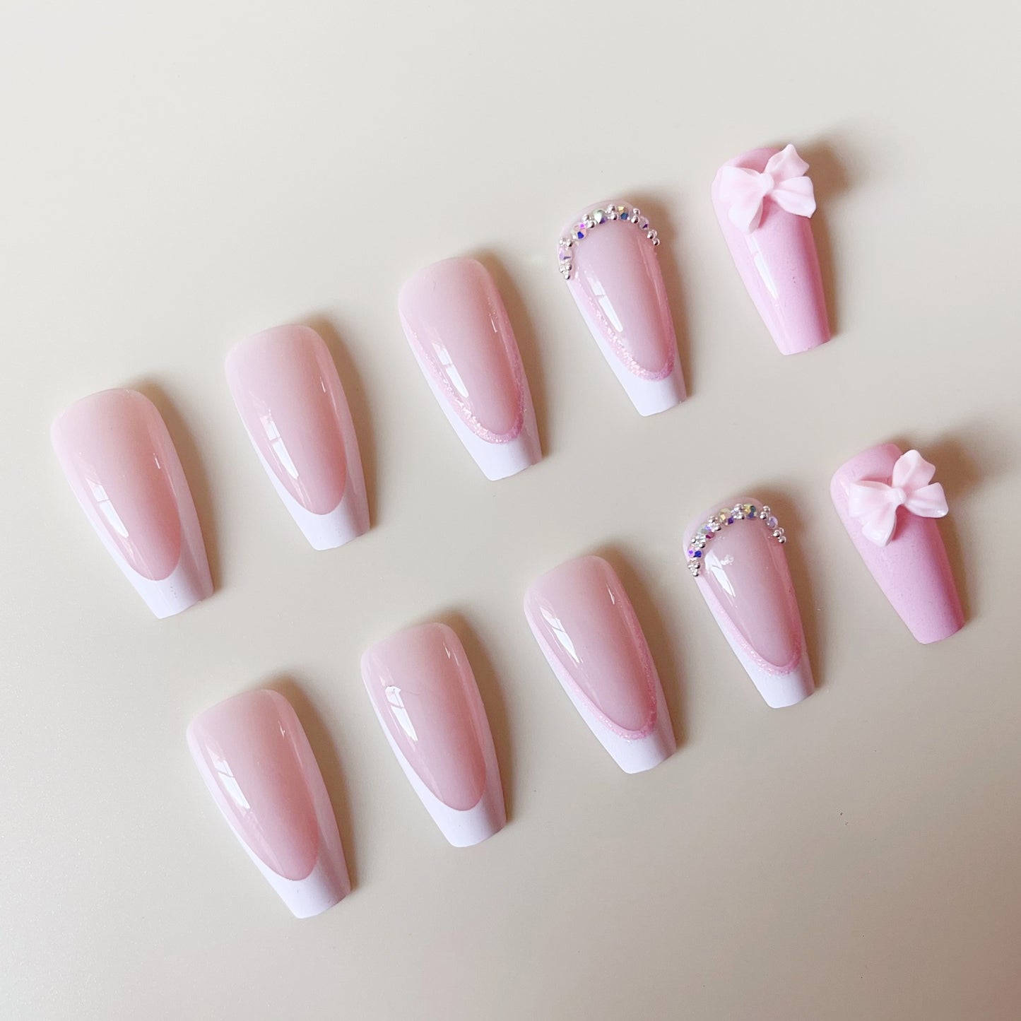 Kunstnagelset mit verspielten Schleifen und Glitzerakzenten Brehn
