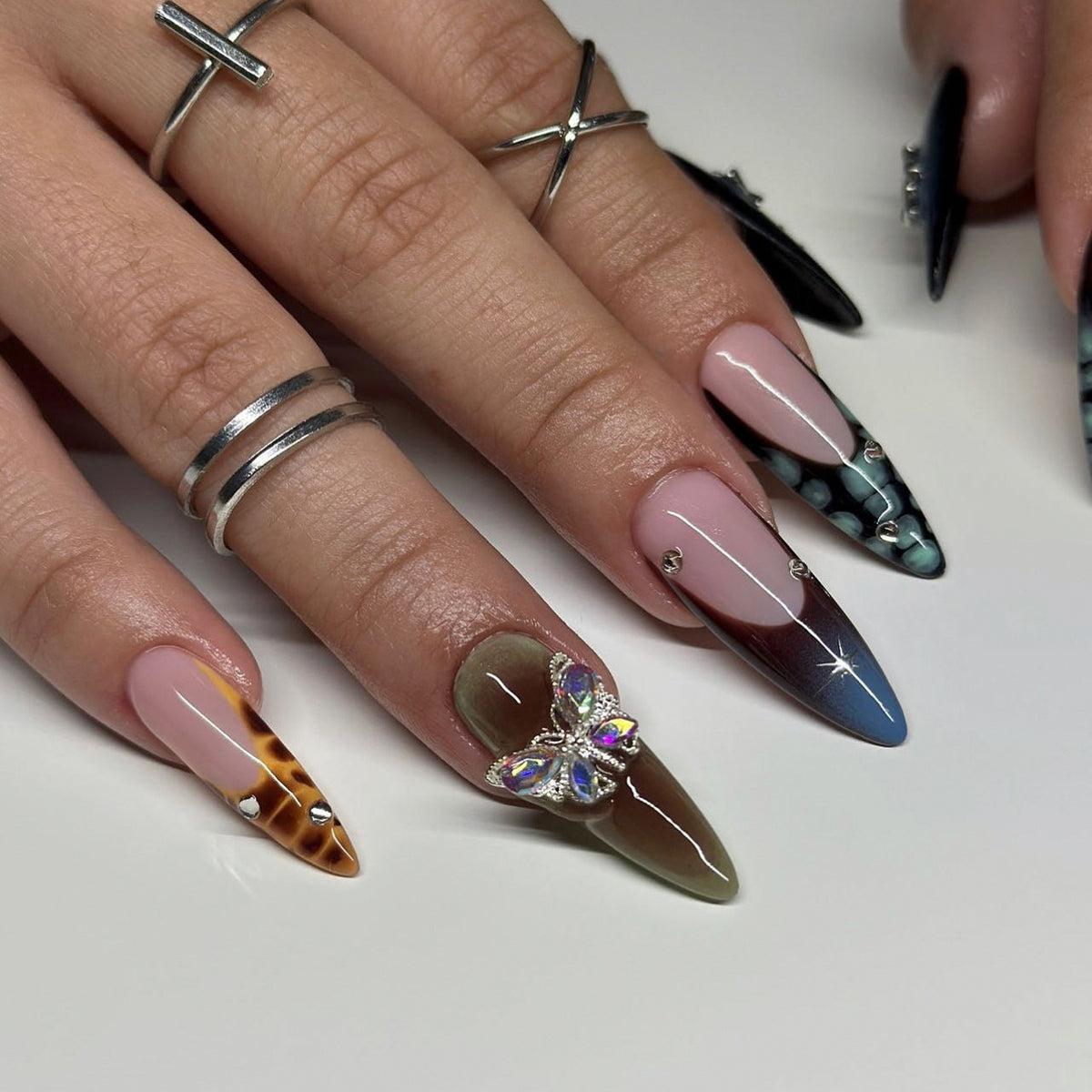 Kunstvolle Nagelverlängerungen mit eleganten Designs und Glitzer Brehn