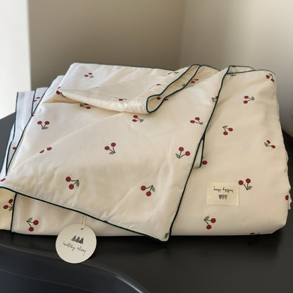 Gesteppte Bettdecke mit Kirsch‑Alloverprint