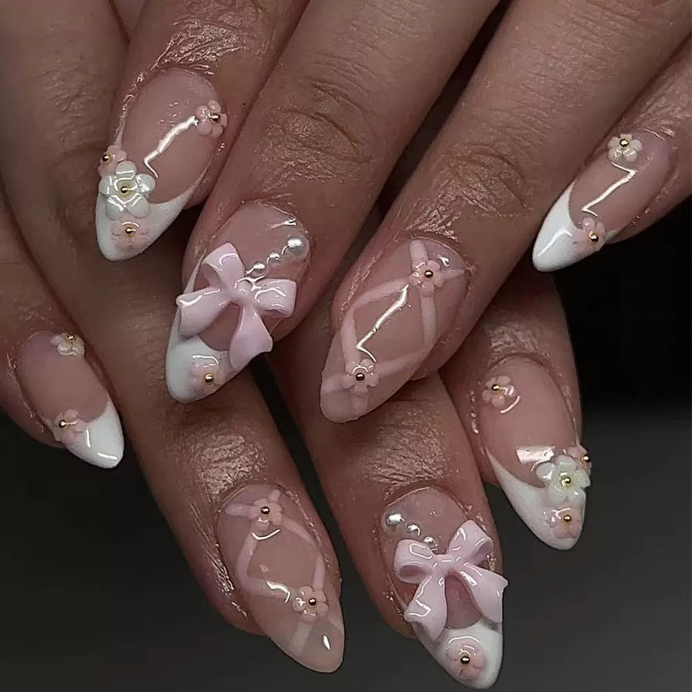 Kunstnagelset mit eleganten Schleifen und floralen Akzenten Brehn