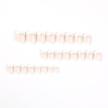 Kunstvolle Nagelverlängerungen mit elegantem French-Tip und Goldakzenten Brehn