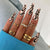 Kunstnagelset mit einzigartigen Wellen-Designs und glamourösen Akzenten Brehn