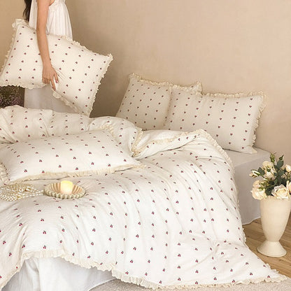 Gestepptes Bettwäscheset aus Baumwoll‑Musselin mit zartem Kirschenprint und Rüschenkante