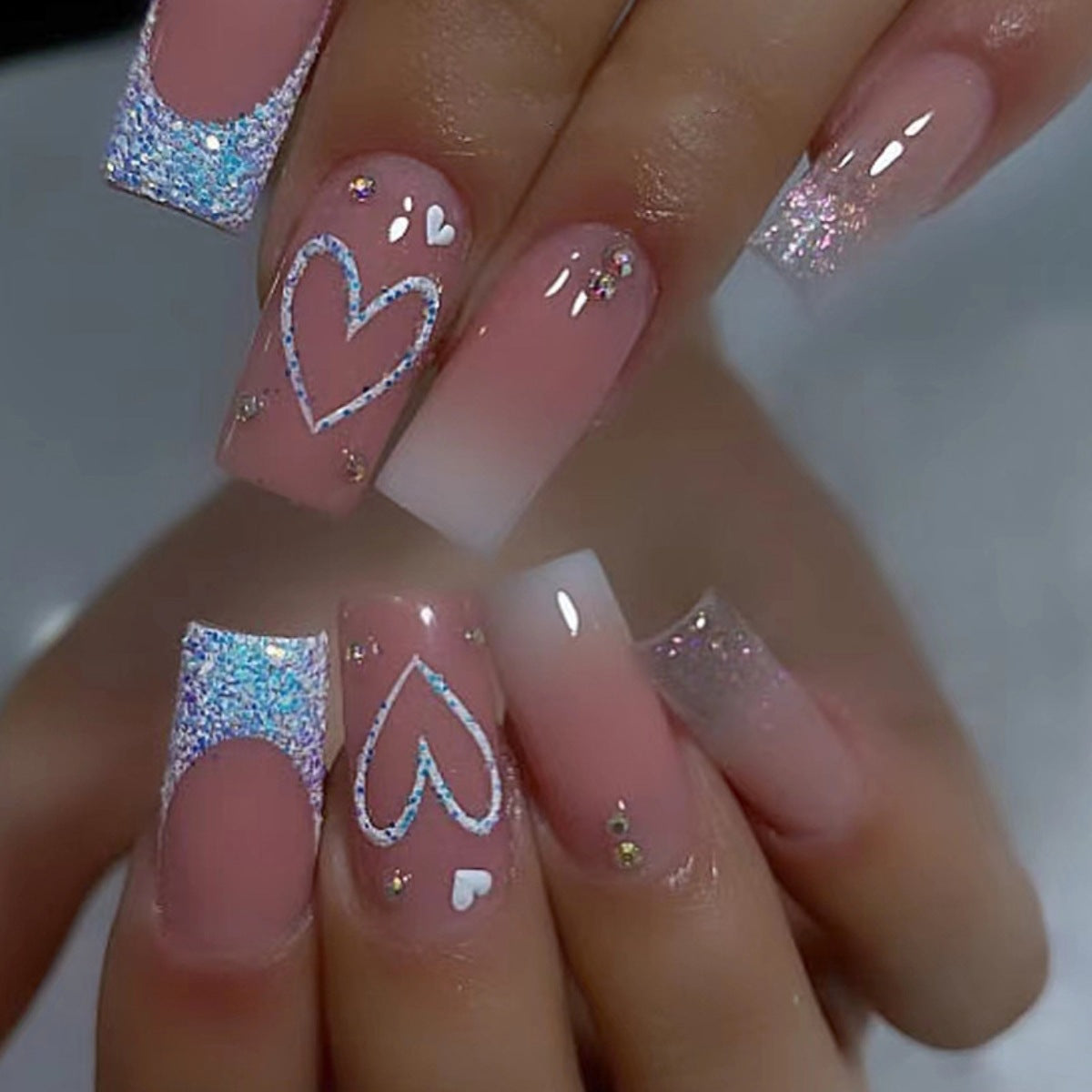 Kunstnägel mit funkelnden Herzmotiven und Glitzerdetails Brehn
