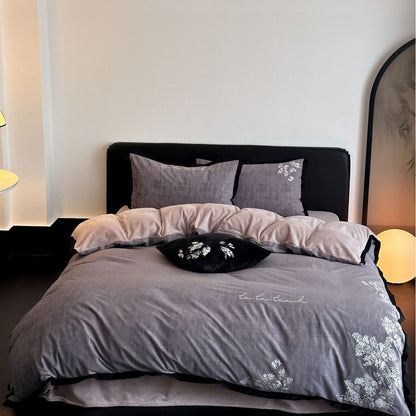 Elegante Bettwäsche-Garnitur aus Baumwollsatin mit zarter Blumenstickerei und kontrastierter Einfassung