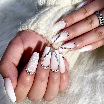 Kunstvolle Nagelverlängerungen mit Herzen-Design und Glitzerakzenten Brehn