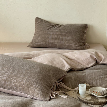 Wendbares Bettwäsche-Set aus Baumwollsatin mit strukturiertem Kreuzmuster und Kissenbezügen mit Bindeband