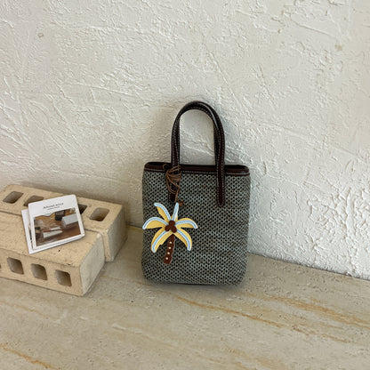 Gewebte Strandhandtasche mit dekorativem Charm