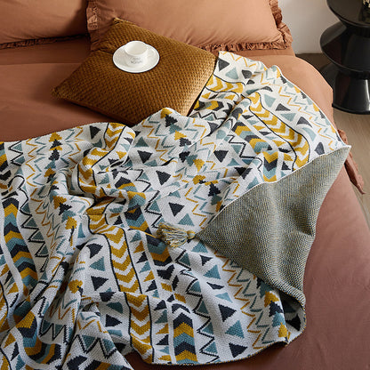 Gemusterte Wohndecke im Ethno-Strickdesign mit Quasten