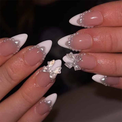 Kunstvolle Nagelverlängerungen mit Perlen- und Schleifenmotiven Brehn