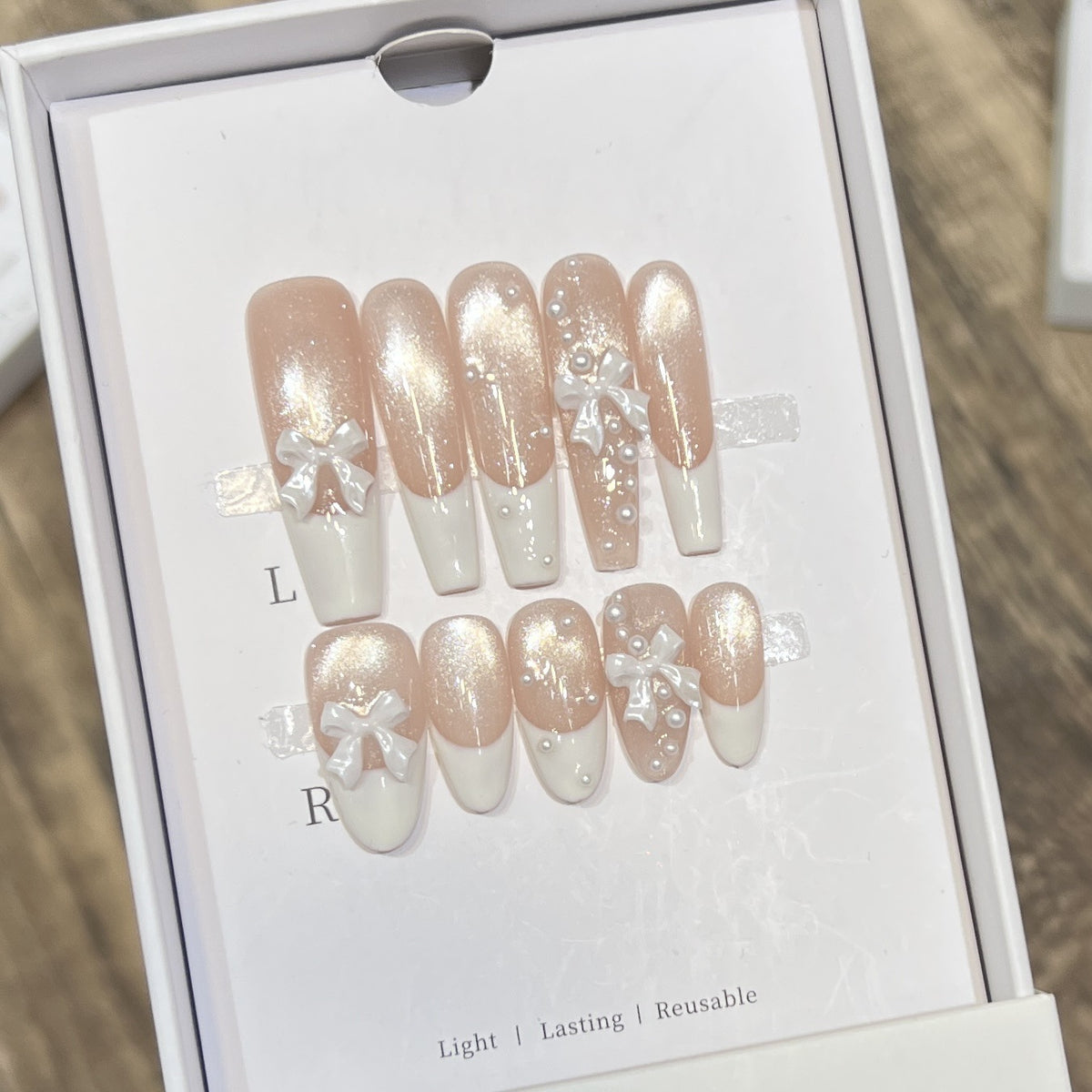 Dekorativer langer Press-On-Nagelset mit Schleife und Perlenakzenten Brehn