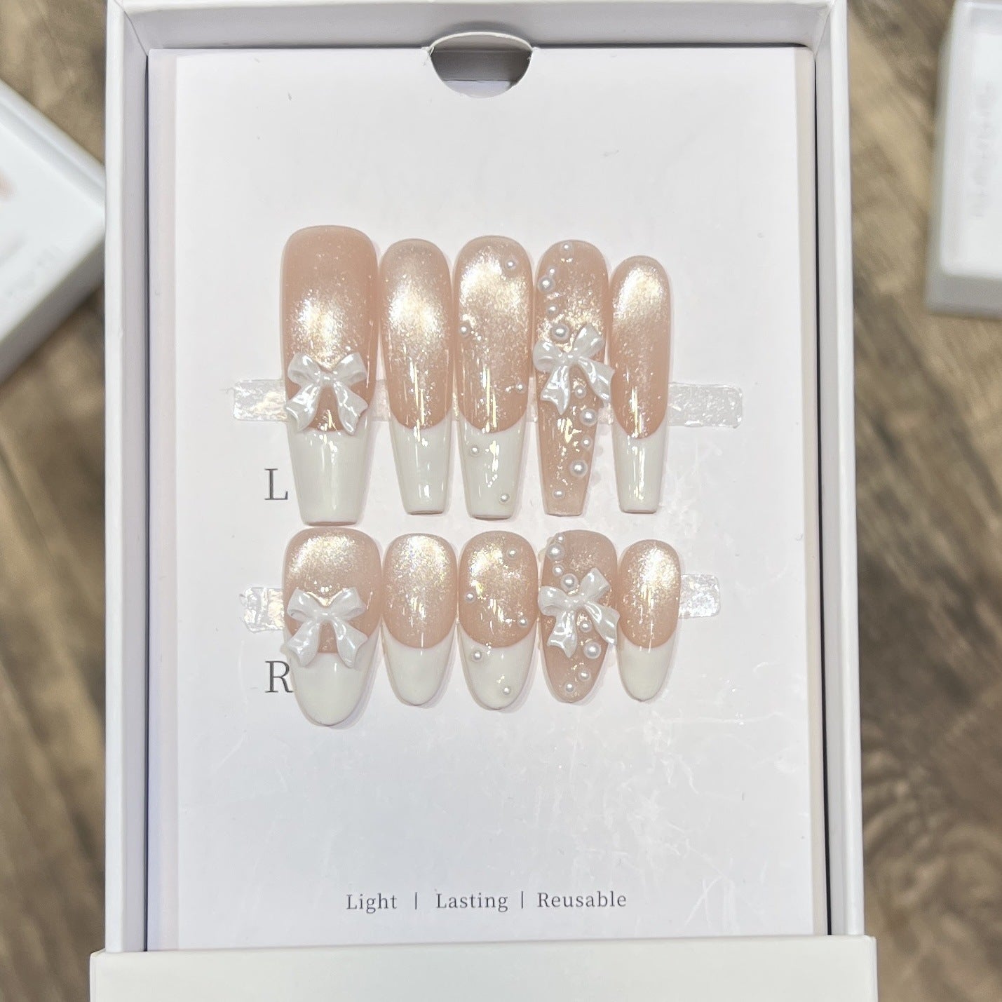 Dekorativer langer Press-On-Nagelset mit Schleife und Perlenakzenten Brehn