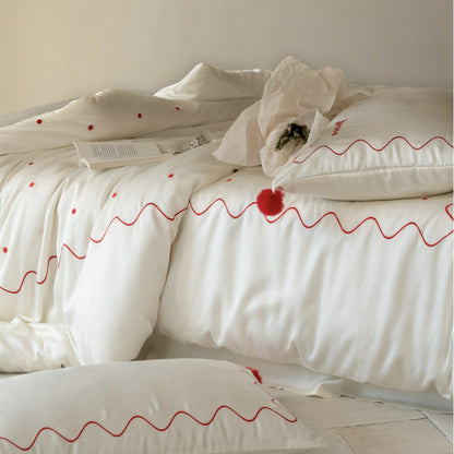 Bettwäsche-Set aus Baumwollsatin mit gewellter Stickkante und Pompon-Kissen
