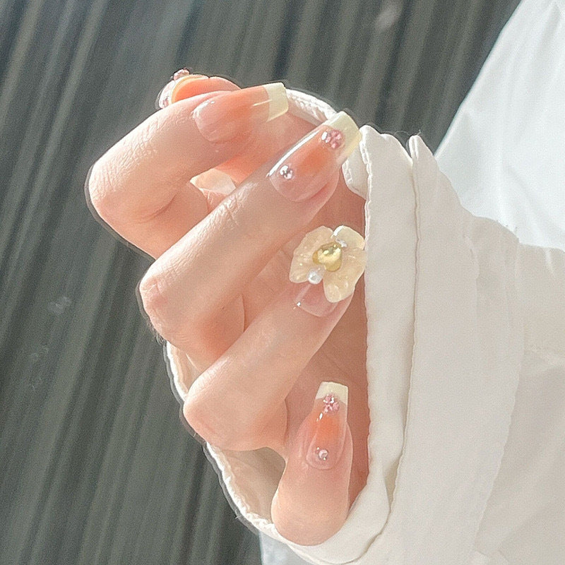 Kunstnagelset mit eleganten Blütenverzierungen und Glitzerakzenten Brehn