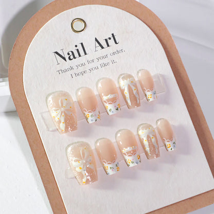 Kunstvolle Nagelverlängerungen mit floralem Design und Schleifenakzenten Brehn