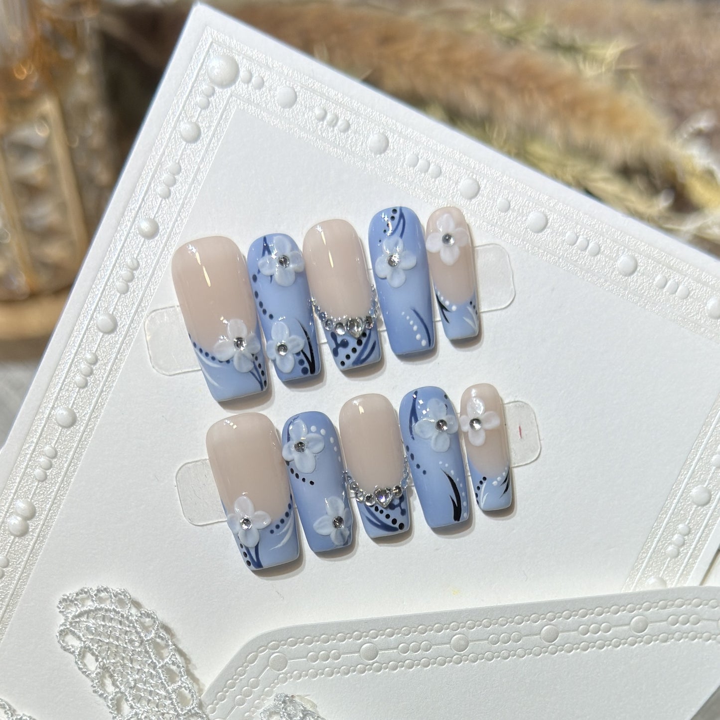 Dekoratives Press-On Nagelkunst-Set mit floralen und edelsteinartigen Details Brehn