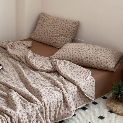 Gesteppte Wohndecke aus Baumwoll‑Mischgewebe mit zartem Blumenmuster und Spitzenkante