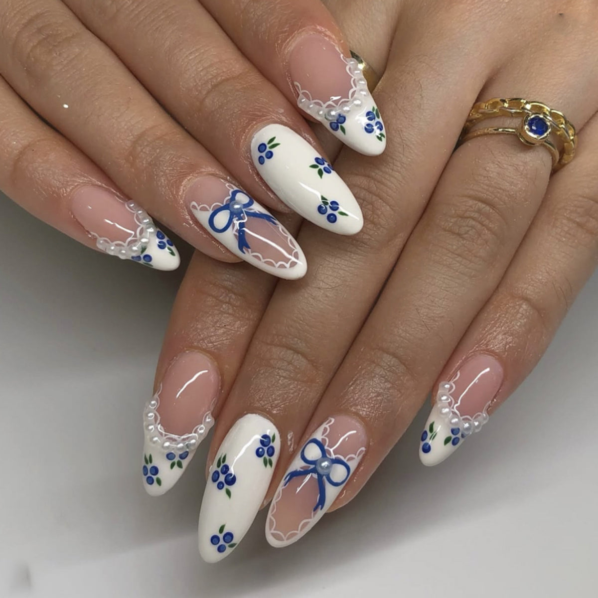 Kunstvolle Nagelkunst mit floralen Akzenten und Schleifenverzierung Brehn