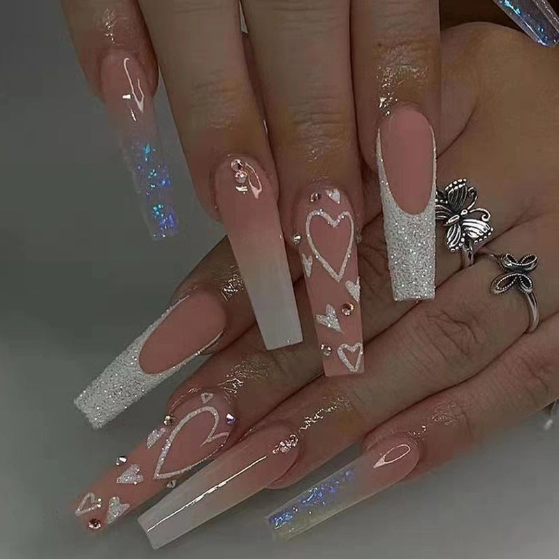 Elegante Kunstnagelspitzen mit Herz- und Glitzermuster Brehn