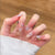 Künstlerisches Press-On-Nagelset mit floralen und glänzenden Akzenten Brehn
