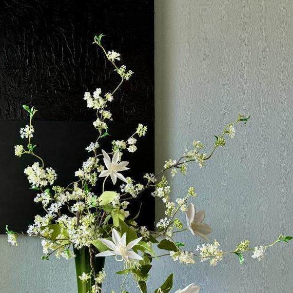 Künstliches Blumenarrangement mit dekorativer grüner Vase