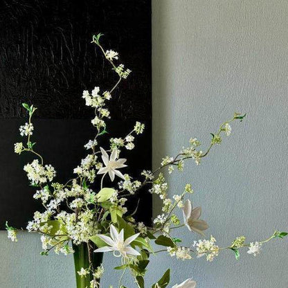 Künstliches Blumenarrangement mit dekorativer grüner Vase