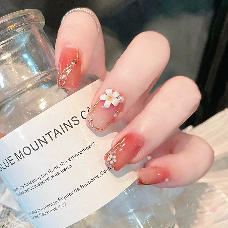 Kunstnagelset mit eleganten Blumendekoren und glamourösen Perlenakzenten Brehn