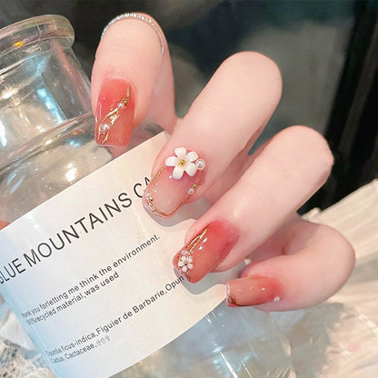 Kunstnagelset mit eleganten Blumendekoren und glamourösen Perlenakzenten Brehn