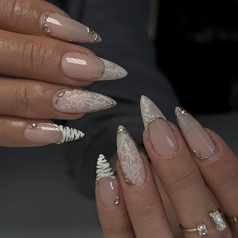 Kunstvolle Stiletto-Nägel mit Gold- und Spitzenverzierungen Brehn