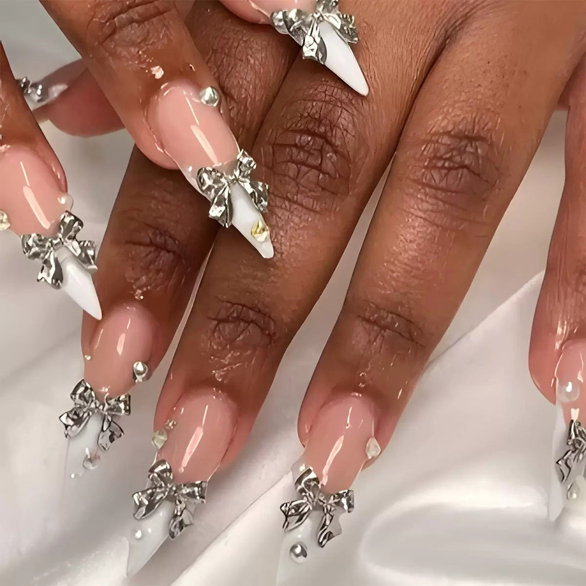 Kunstnagelset mit eleganten Schleifen und funkelnden Akzenten Brehn