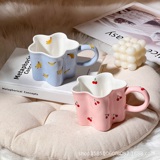 Kaffeebecher aus Keramik mit blütenförmiger Wellenkante, illustrativem Bananendekor und ergonomischem Henkel