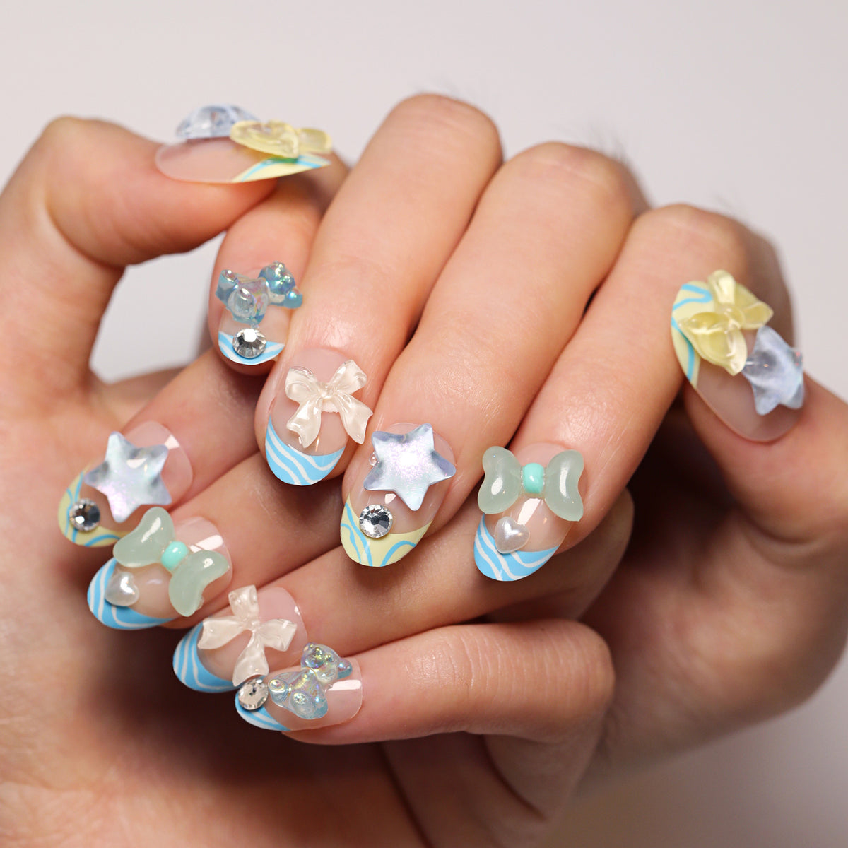 Künstliche Nagelkunst mit bunten Pastellmotiven und 3D-Verzierungen Brehn