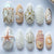 luxuriöses Kunstnagelset mit maritimen Designs und goldenen Akzenten Brehn