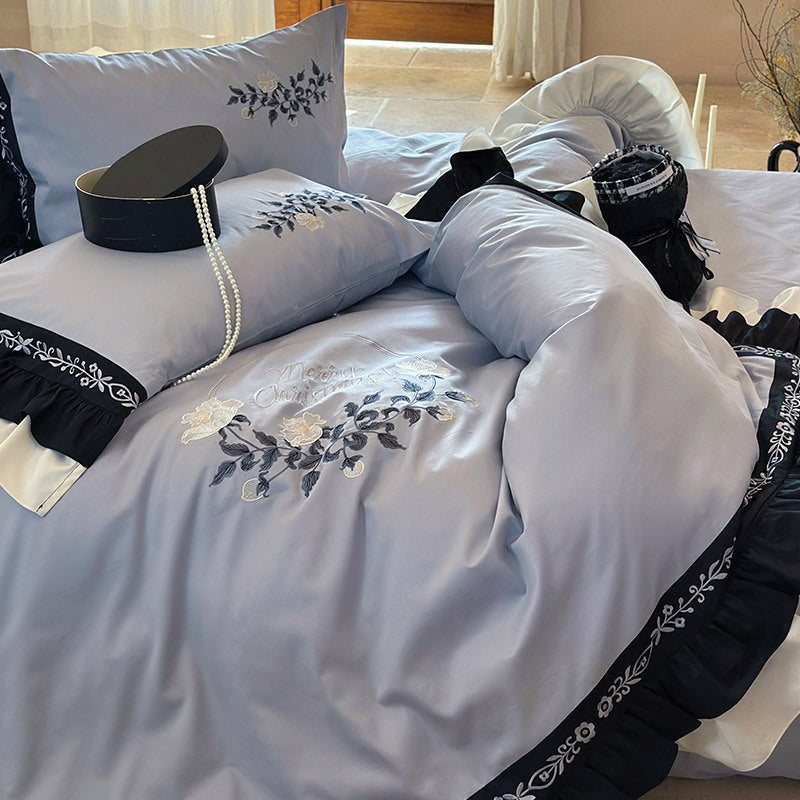 Elegante Bettwäsche-Garnitur aus Baumwollsatin mit Stickerei, kontrastierendem Volant und Rundkissen