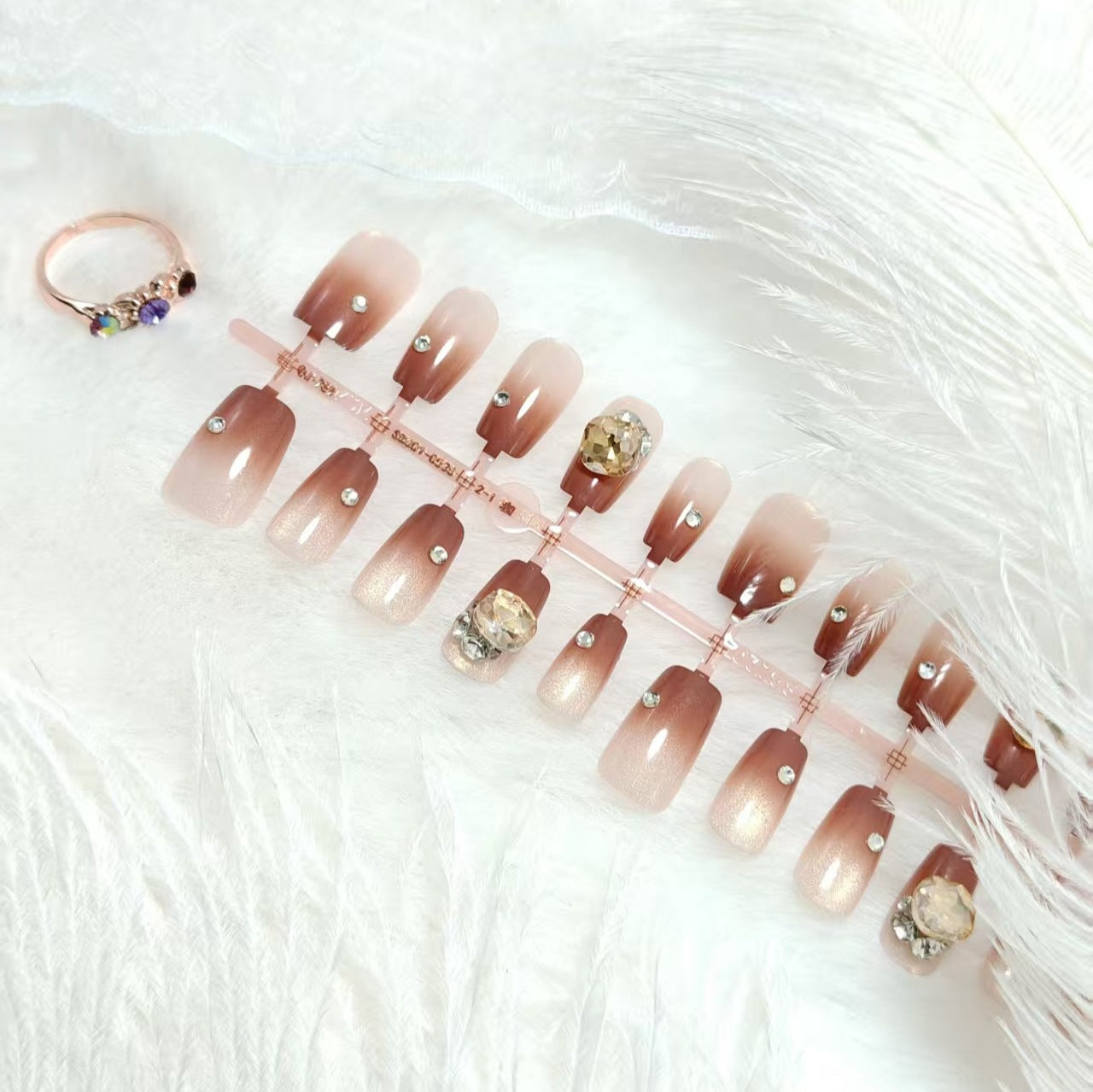 Kunstnägel im eleganten Ombre-Stil mit strassverzierten Applikationen Brehn