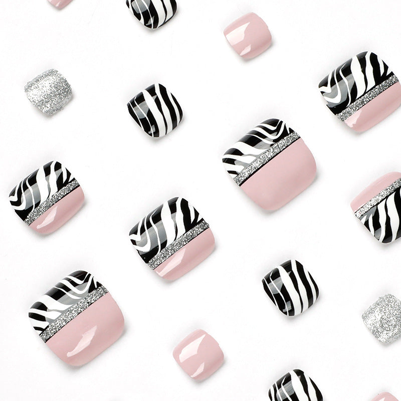 Kunstvolle Fußnagelkunst mit Zebra-Muster und Glitzerakzenten Brehn