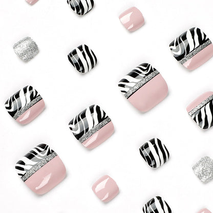 Kunstvolle Fußnagelkunst mit Zebra-Muster und Glitzerakzenten Brehn