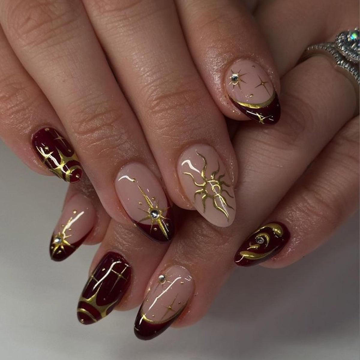 Kunstvolle Nagelkunst mit goldenen Akzenten und mystischen Motiven Brehn