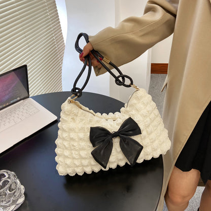 Texturierte Handtasche mit Schleifenverzierung