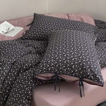 Wendbare Bettwäsche‑Garnitur aus Baumwollsatin mit feinem Blumenallover, kontrastierter Innenseite und dekorativen Schleifen
