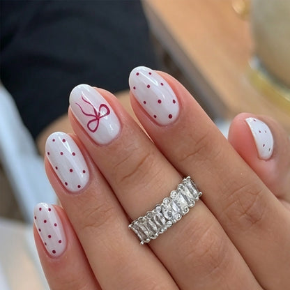 Kunstnagelset mit zarten Punkten und Schleifenmuster Brehn