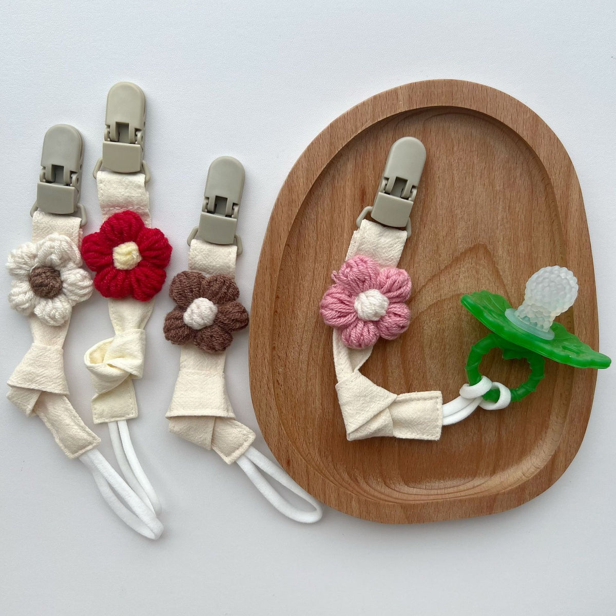 Handgemachter Baumwoll-Schnullerclip mit Gingham-Gurt und gestrickter Blume