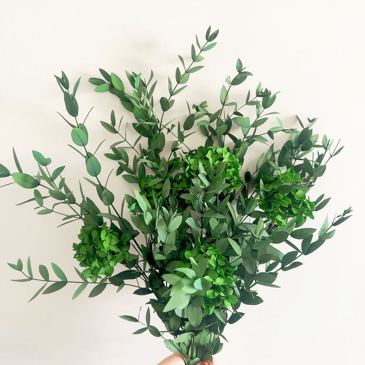 Lebensechter Blumenstrauß mit grünen Blättern