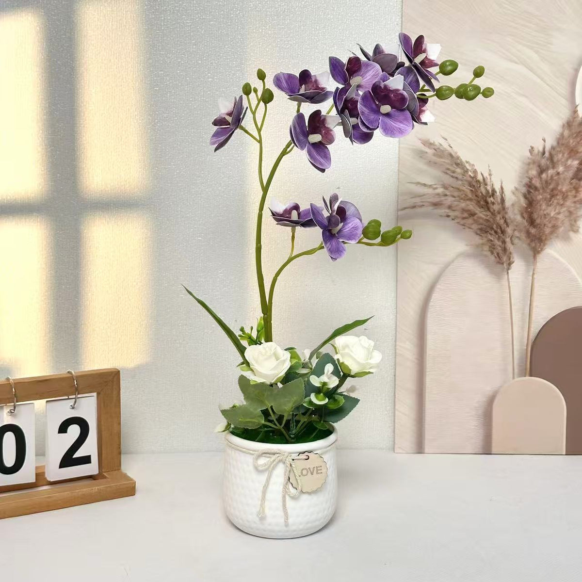 Lebensechte Orchideen- und Rosenblumenarrangement