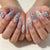 Künstlerisches Press-On-Nageldesign mit floralen und Schmuckakzenten Brehn