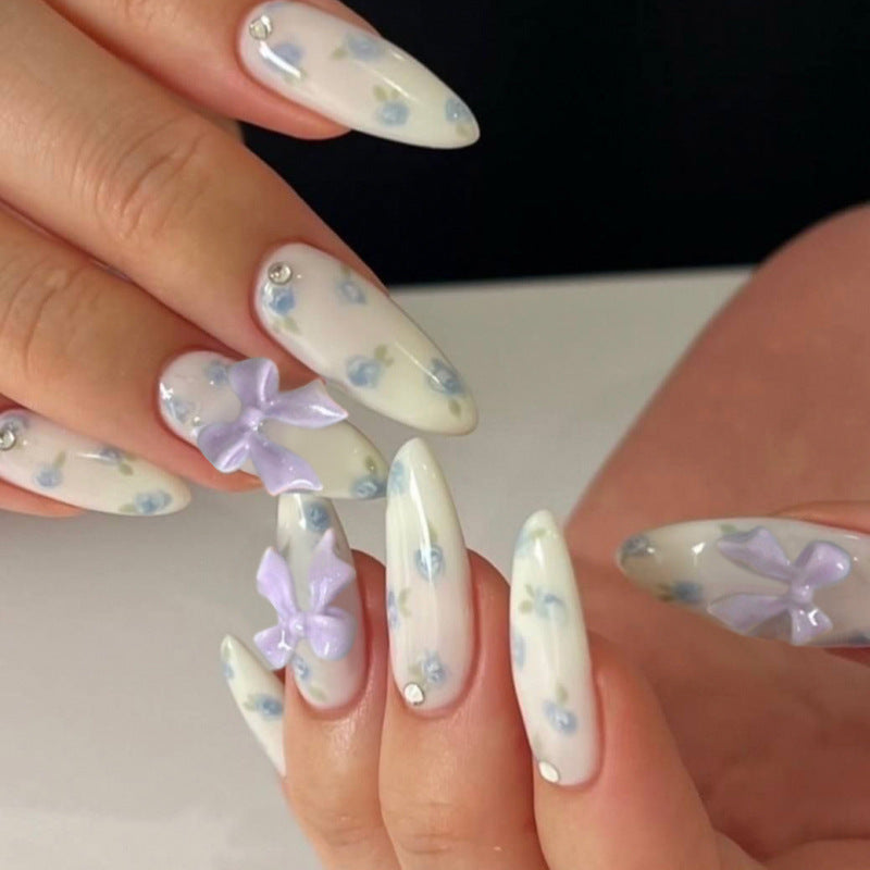 Kunstvolle Nagelkunst mit Blumen-Design und Blauem French Tip Brehn